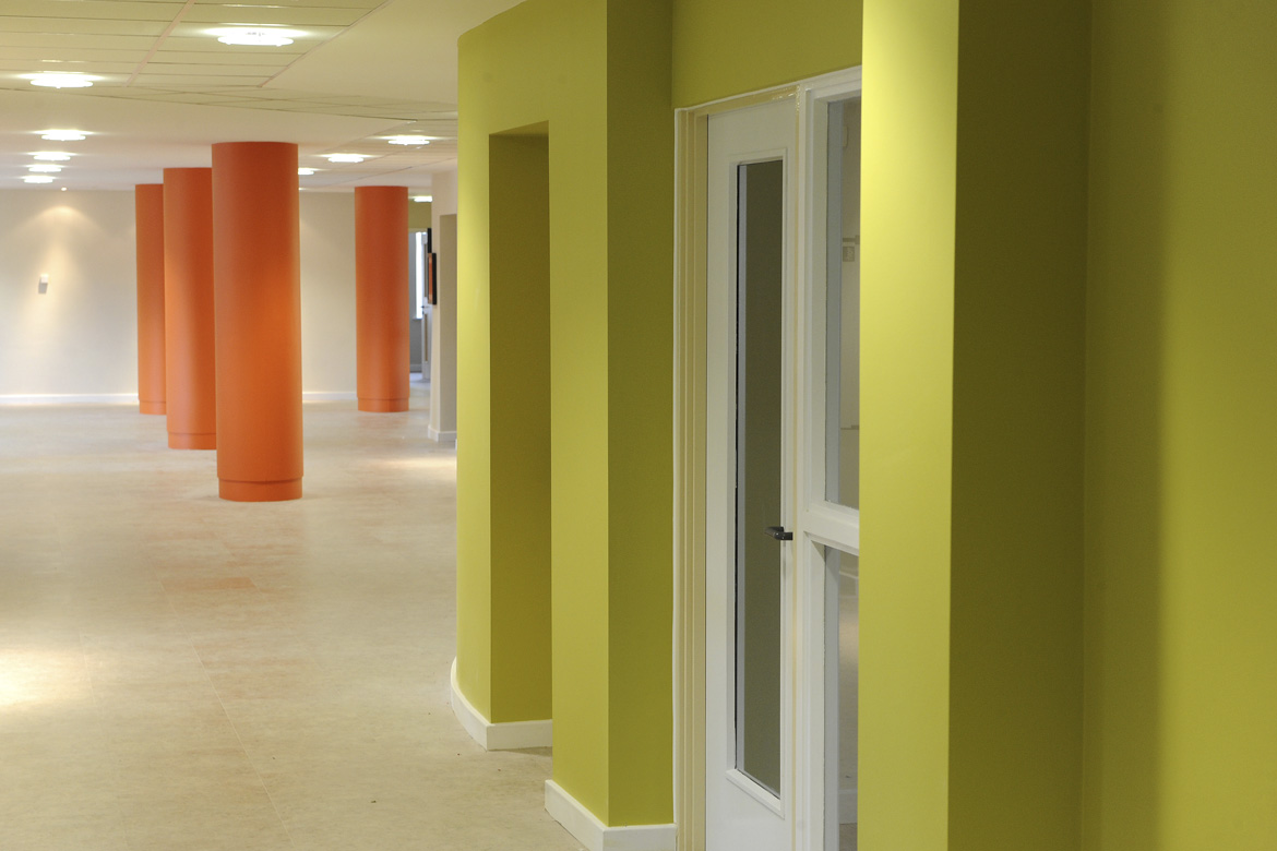 a room with orange pillars and green walls